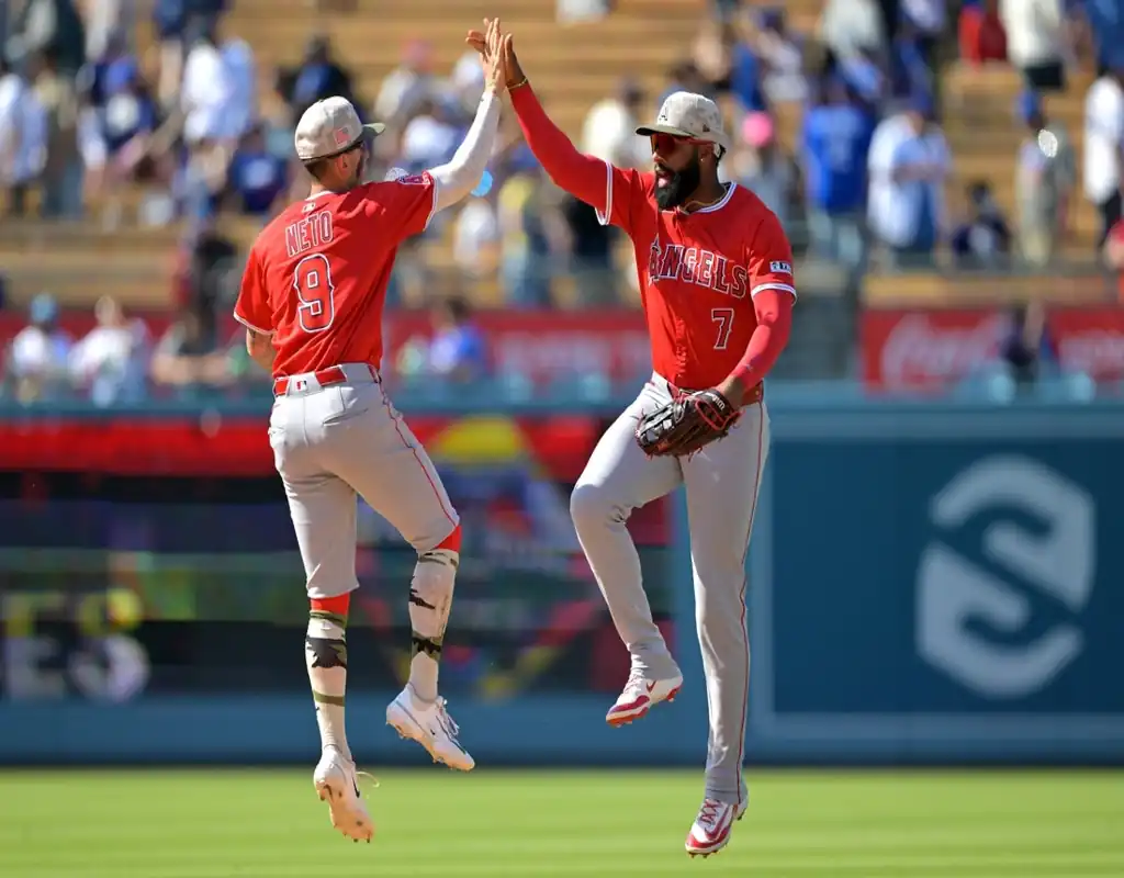 Los Angeles Angels players celebrate with a high-five during a game against the Oakland Athletics on May 19, 2025