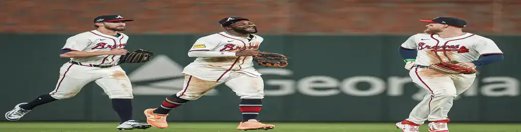Atlanta Braves outfielders celebrating together on the field after making a play.
