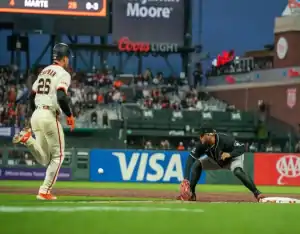 Arizona Diamondbacks first baseman stretches for throw as San Francisco Giants runner approaches during May 13, 2025 MLB game