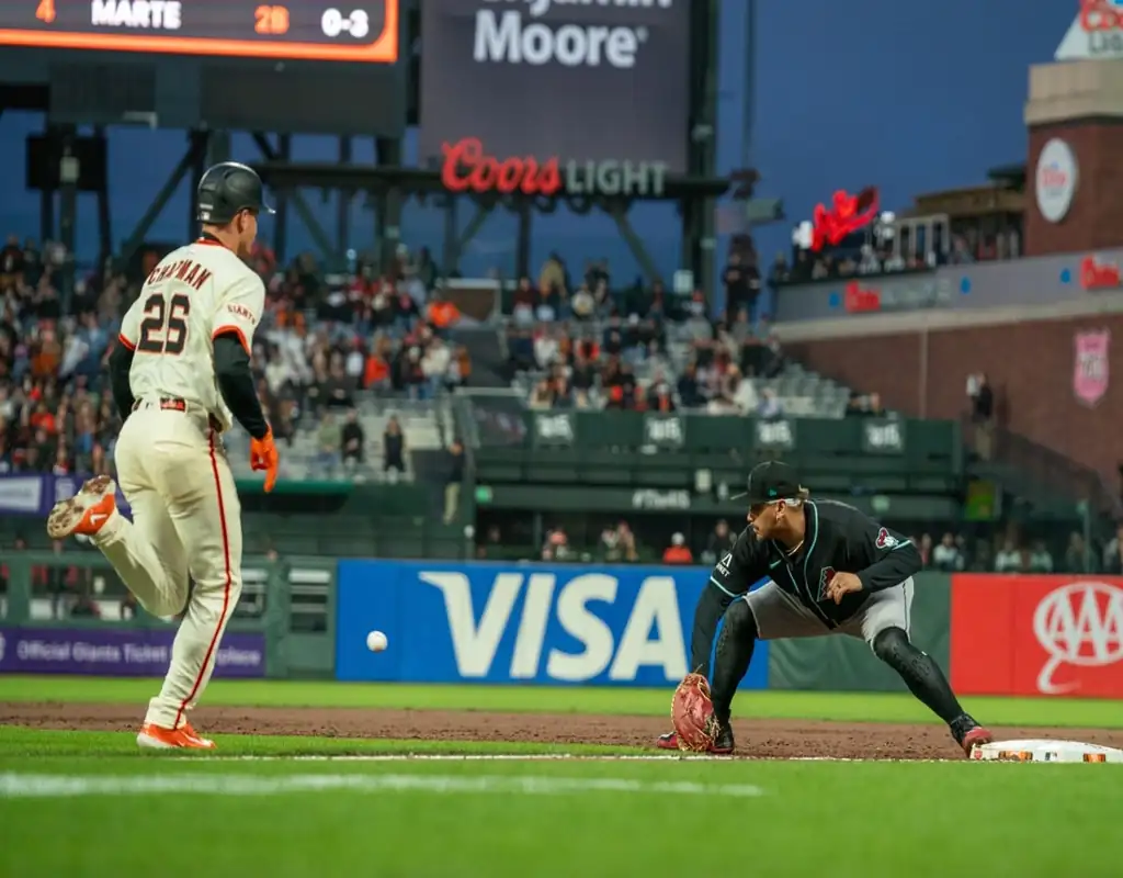 Arizona Diamondbacks first baseman stretches for throw as San Francisco Giants runner approaches during May 13, 2025 MLB game