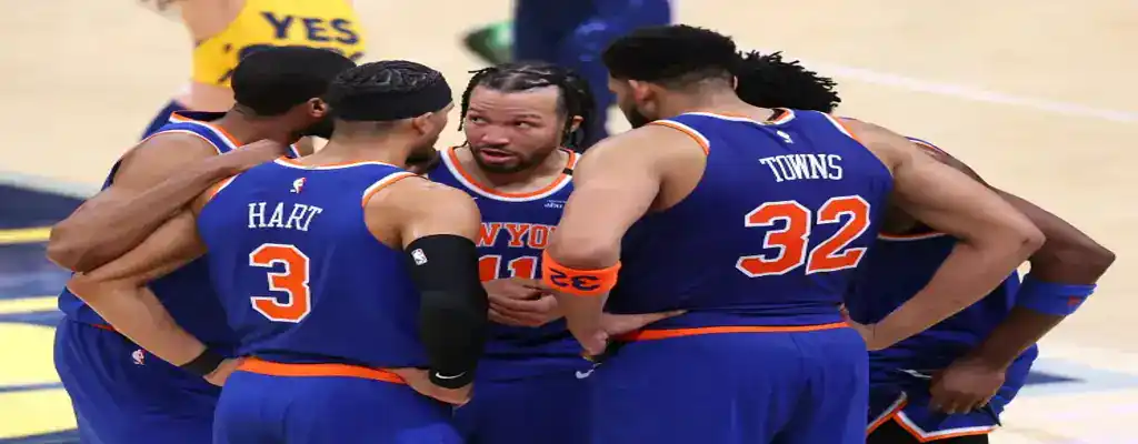 Indiana Pacers vs New York Knicks Picks and Predictions May 31st 2025 2 New York Knicks players huddle during a game to strategize on the court, wearing blue uniforms with visible names and numbers.