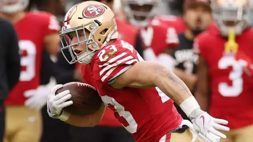 Christian McCaffrey de los San Francisco 49ers corre con el balón durante un partido, destacado como uno de los principales candidatos a liderar en yardas por tierra en la temporada 2024-25 de la NFL.