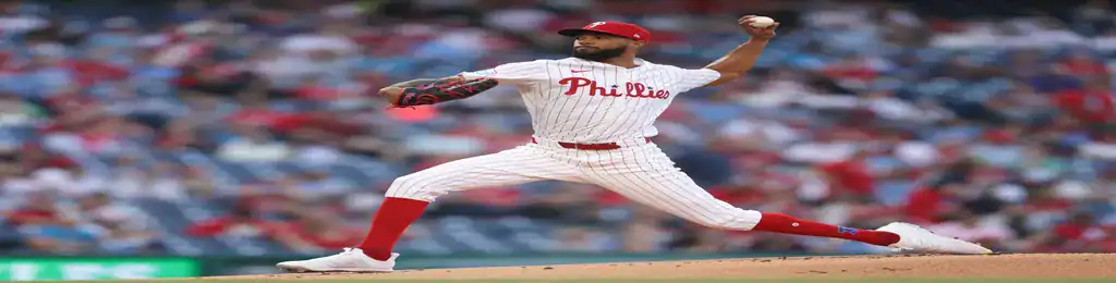 Philadelphia Phillies pitcher in pinstripe uniform delivering a pitch from the mound during a game.