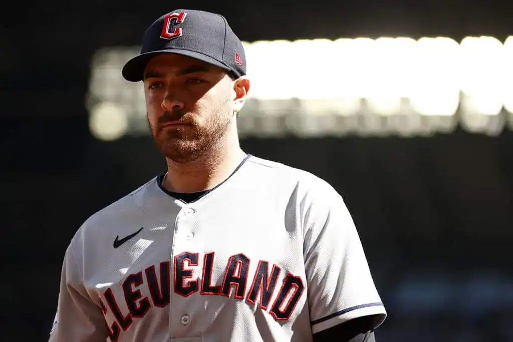 Milwaukee Brewers vs Atlanta Braves Picks and Predictions June 9th 2025 2 A player in a gray Cleveland baseball jersey stands on the field, wearing a black cap with a red "C" logo. Bright lights are visible in the background.