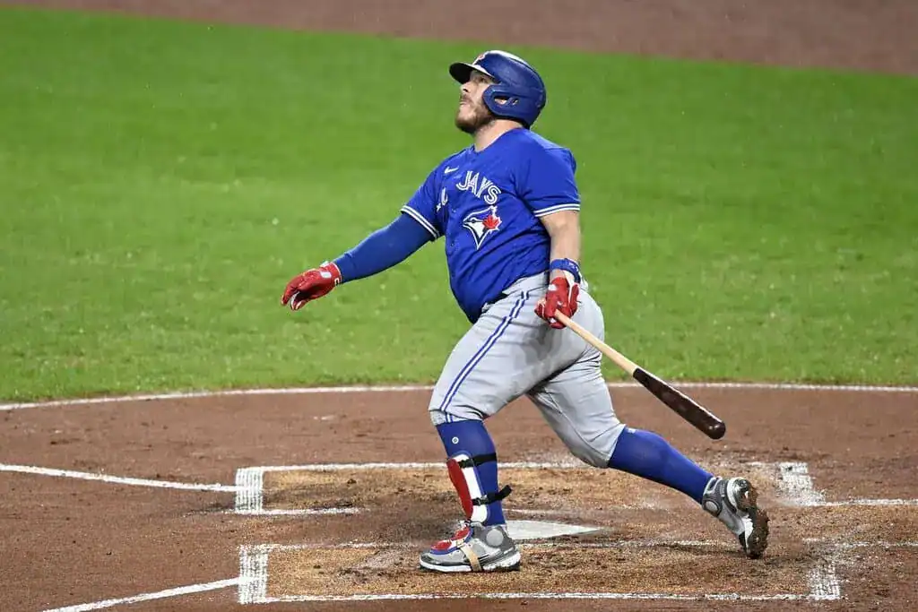Philadelphia Phillies vs Toronto Blue Jays Picks and Predictions June 13th 2025 2 A baseball player in a blue jersey swings a bat powerfully, capturing the action during a game on a grassy field.