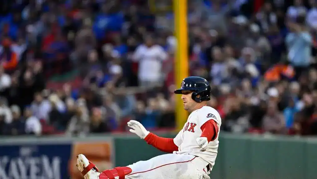 Houston Astros vs Minnesota Twins Picks and Predictions June 13th 2025 2 A Boston Red Sox player slides into base during a game, with the crowd cheering in the background.