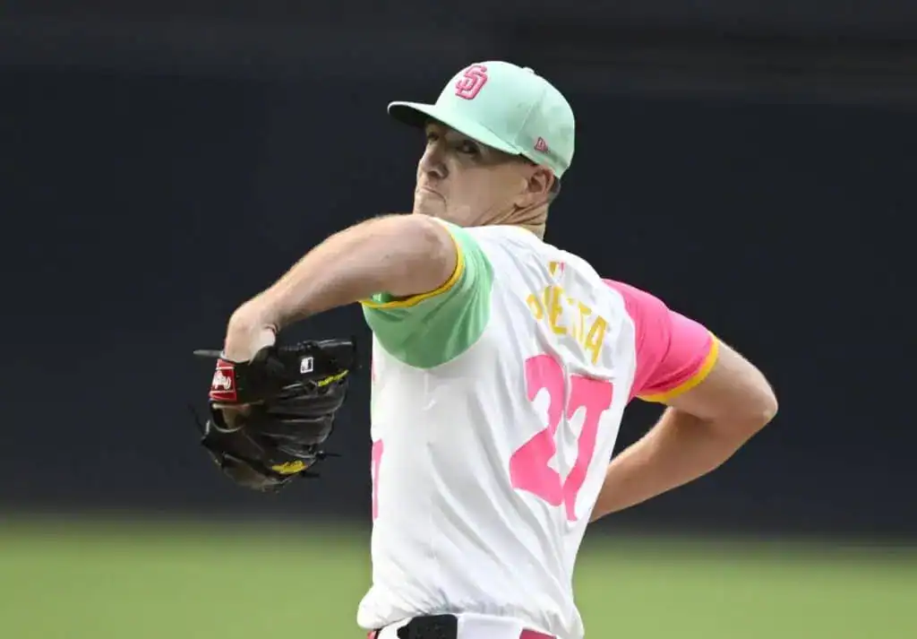 A pitcher in a vibrant jersey prepares to throw a baseball