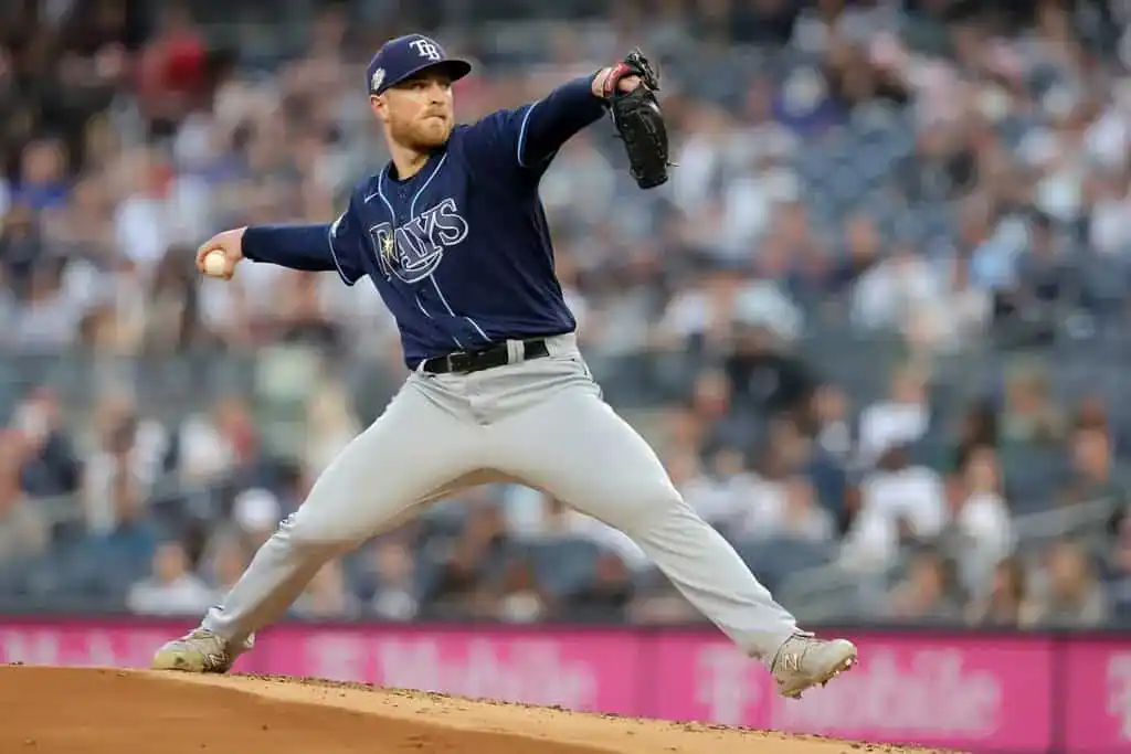 Tampa Bay Rays vs Oakland Athletics Picks and Predictions June 30th 2025 2 A baseball pitcher in a blue Rays uniform throws a pitch on the mound, with a blurred audience in the background.