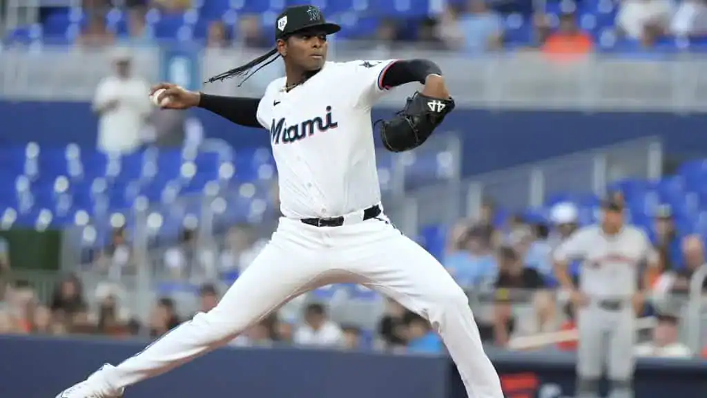 Washington Nationals vs Miami Marlins Picks and Predictions June 13th 2025 2 A Miami baseball player in a white uniform winds up to pitch on the field, with fans seated in the blue stands behind him.