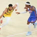 A player in a yellow Indiana jersey dribbles a basketball while being closely defended by a player in a blue Thunder uniform.