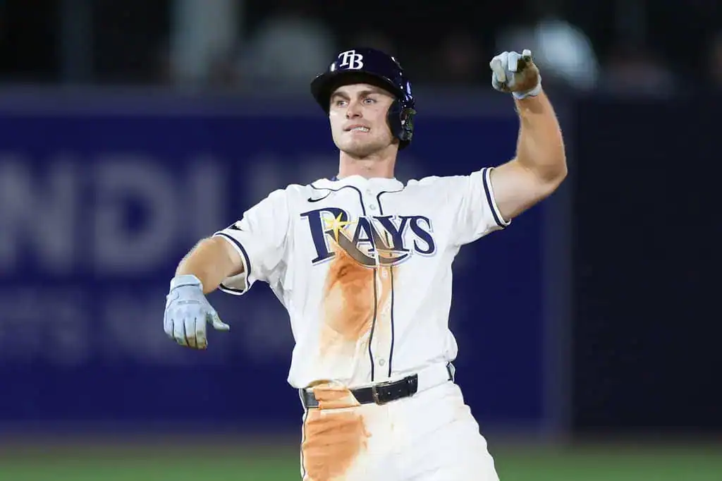 New York Mets vs Tampa Bay Rays Picks and Predictions June 15th 2025 2 A baseball player in a white uniform with blue accents celebrates joyfully after a play, showing dirt stains on the front of his outfit.