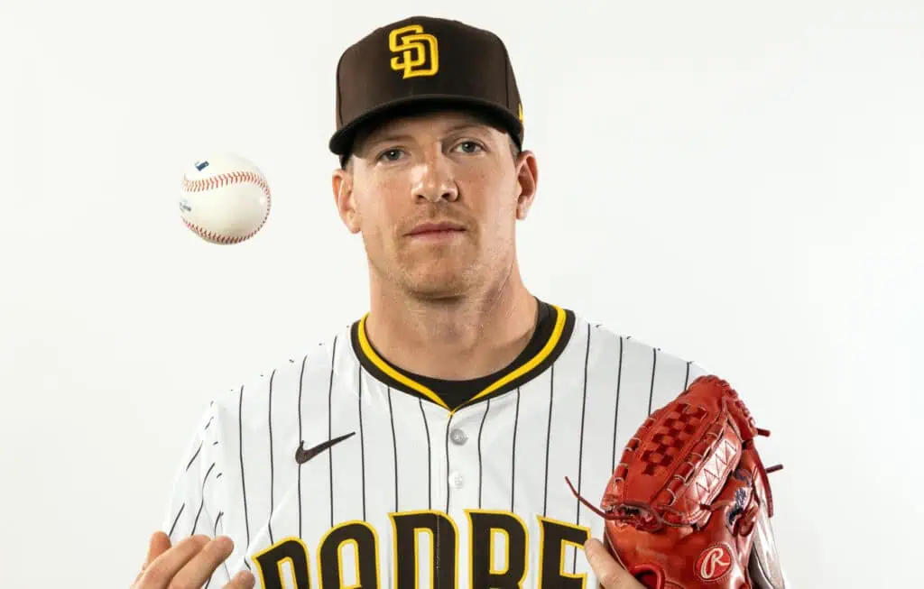 San Diego Padres vs Kansas City Royals Picks and Predictions June 20th 2025 2 A baseball player in a striped San Diego Padres jersey holds a red glove, with a baseball floating in the air beside him.