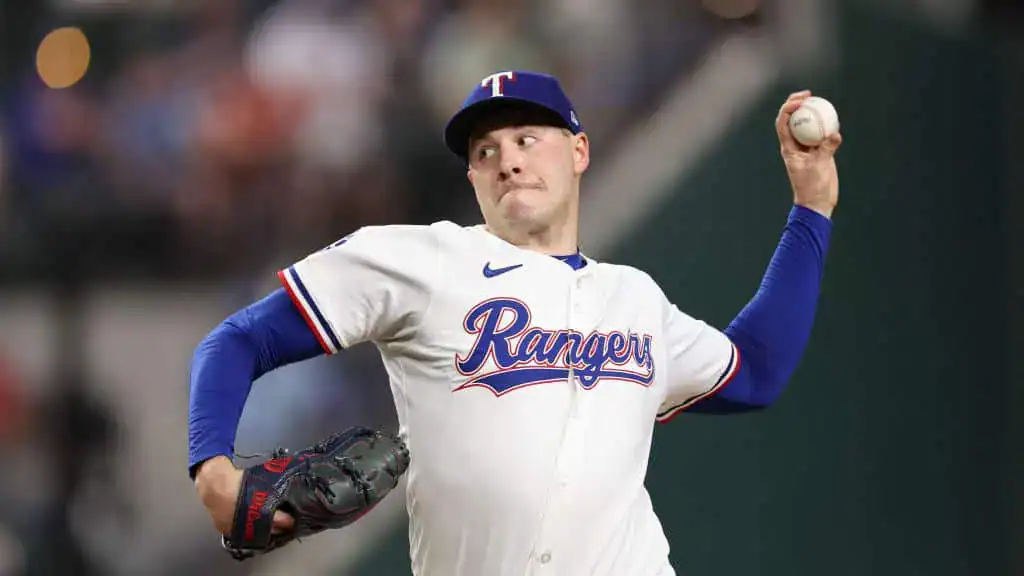 Washington Nationals vs Texas Rangers Picks and Predictions June 6th 2025 2 A baseball player in a Texas Rangers uniform winds up to pitch, gripping a baseball in his right hand, with a focused stance.