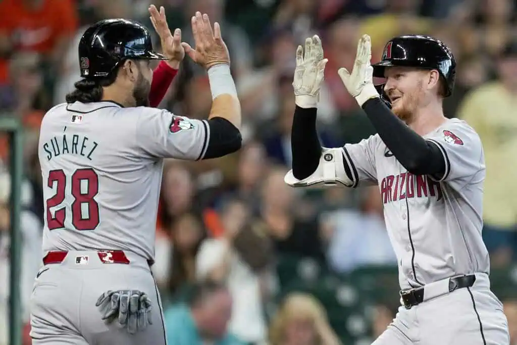 Chicago White Sox vs Arizona Diamondbacks Picks and Predictions June 24th 2025 2 Two baseball players in gray uniforms celebrate a scoring play, one with the name "Suarez" and number 28 visible on his back.