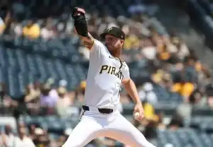A Pittsburgh Pirates pitcher winds up to throw a pitch during a sunny day at the baseball stadium