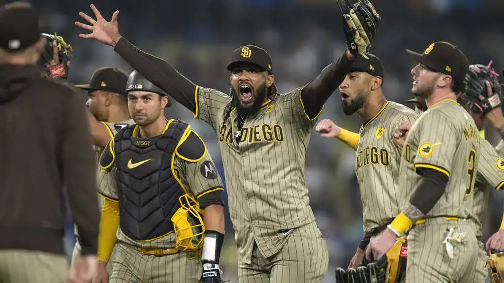Arizona Diamondbacks vs San Diego Padres Picks and Predictions June 13th 2025 2 A group of San Diego Padres players celebrating a victory on the baseball field, wearing their distinctive tan-striped uniforms.