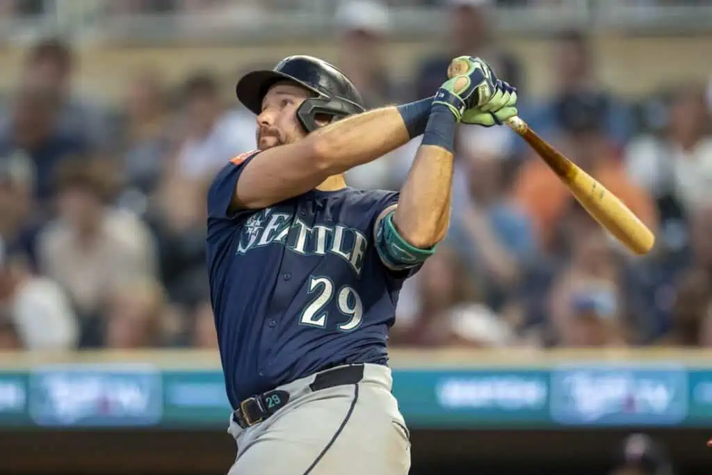 A baseball player in a blue Seattle Mariners uniform prepares to swing a bat during a game.