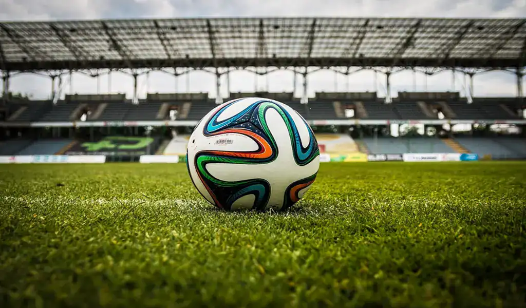 How To Get the Most Out of Your Betting Bonuses 2 Soccer ball resting on green grass field in a stadium with empty stands.
