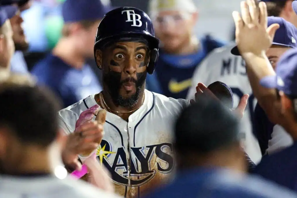 A baseball team celebrates a player's achievement in the dugout, with players giving high-fives