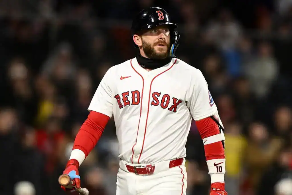 Boston Red Sox vs New York Yankees Picks and Predictions June 15th 2025 2 A Boston Red Sox player stands on the field, holding a bat, wearing a white jersey with red accents and the team logo.