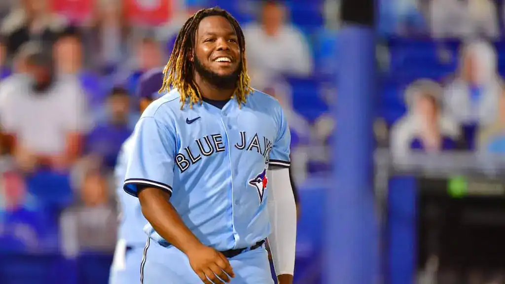 Boston Red Sox vs Toronto Blue Jays Picks and Predictions June 27th 2025 2 Smiling baseball player in a light blue jersey with "Blue Jays" text, walking on a field.