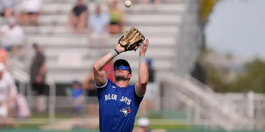 Toronto Blue Jays vs Arizona Diamondbacks Picks and Predictions June 18th 2025 2 A Blue Jays player with a glove prepares to catch a baseball during a game, surrounded by a crowd in the stadium stands.