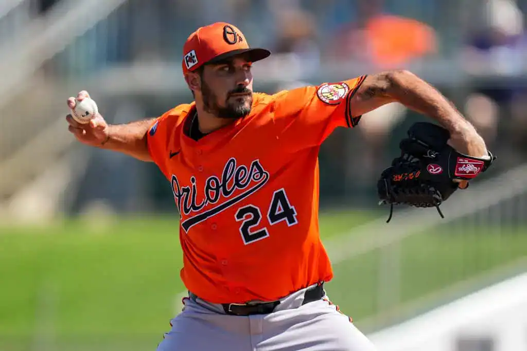 Tampa Bay Rays vs Baltimore Orioles Picks and Predictions June 16th 2025 2 A Baltimore Orioles pitcher in an orange jersey prepares to throw a baseball, showcasing a focused expression and athletic stance.