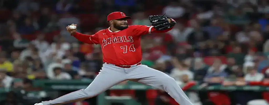 Los Angeles Angels pitcher in red uniform delivers a powerful pitch during a night game, surrounded by fans.