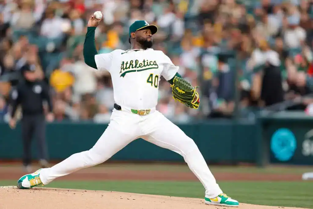 Kansas City Royals vs Oakland Athletics Picks and Predictions June 13th 2025 2 A pitcher in a white Oakland Athletics uniform prepares to throw a baseball on the field, showcasing a dynamic pitching stance.