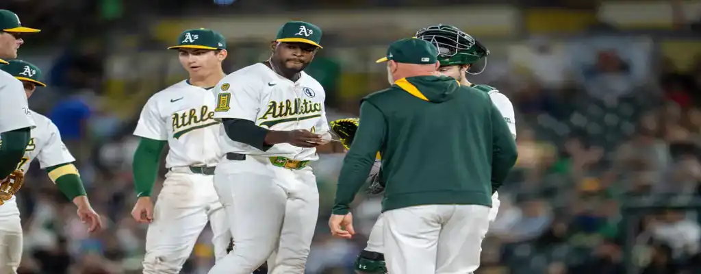 Oakland Athletics vs Minnesota Twins Picks and Predictions June 4th 2025 3 Oakland Athletics pitcher hands the ball to the coach during a mound visit, surrounded by teammates in white uniforms.