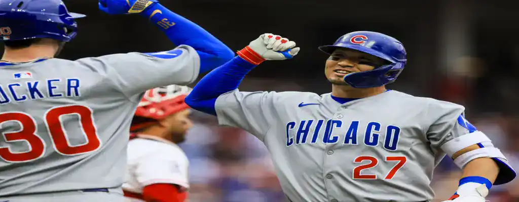 Detroit Tigers vs Chicago Cubs Picks and Predictions June 7th 2025 2 Chicago Cubs players celebrate a run with a forearm bash at home plate, wearing gray road uniforms during a game.