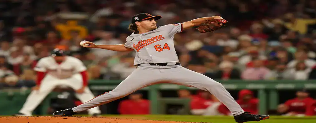 Baltimore Orioles pitcher in mid-throw on the mound during a night MLB game
