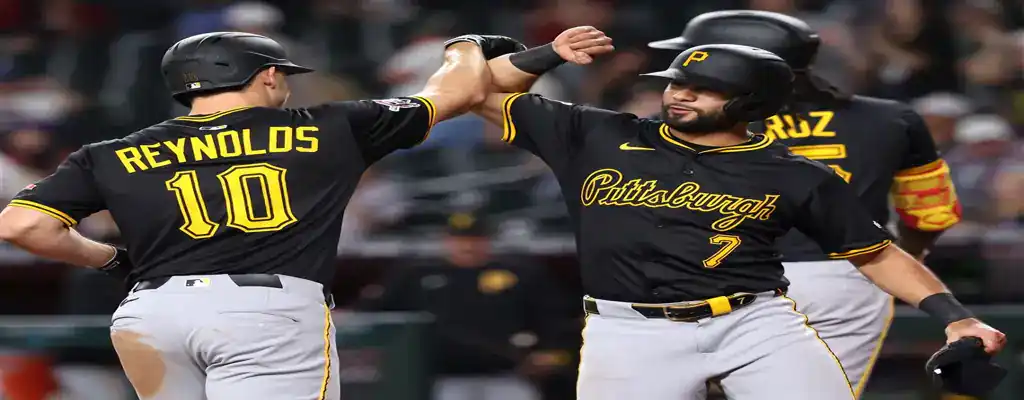 Pittsburgh Pirates vs Houston Astros Picks and Predictions June 5th 2025 3 Pittsburgh Pirates players celebrate a scoring play with a fist bump, wearing black and yellow uniforms under stadium lights.