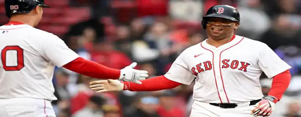 Boston Red Sox vs Los Angeles Angels Picks and Predictions June 4th 2025 2 Boston Red Sox players celebrate a run at home plate, exchanging a high five while smiling in white uniforms.