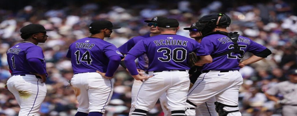Colorado Rockies vs Arizona Diamondbacks Picks and Predictions June 20th 2025 3 Colorado Rockies players in purple uniforms gather on the mound during an MLB game