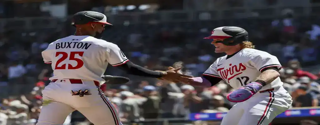 Minnesota Twins vs Toronto Blue Jays Picks and Predictions June 7th 2025 3 Minnesota Twins players celebrate a run at home plate with a handshake, wearing white home uniforms during a day game.
