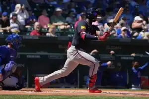 The image shows a baseball batter in action, bat raised, about to hit the ball.