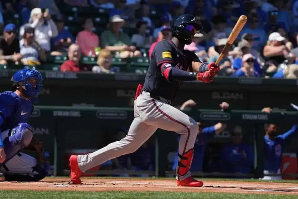 The image shows a baseball batter in action, bat raised, about to hit the ball.