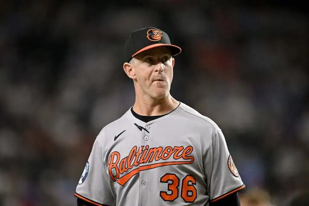 The image features a man dressed in a baseball uniform. He is likely participating in or representing the sport of baseball, which is played outdoors.