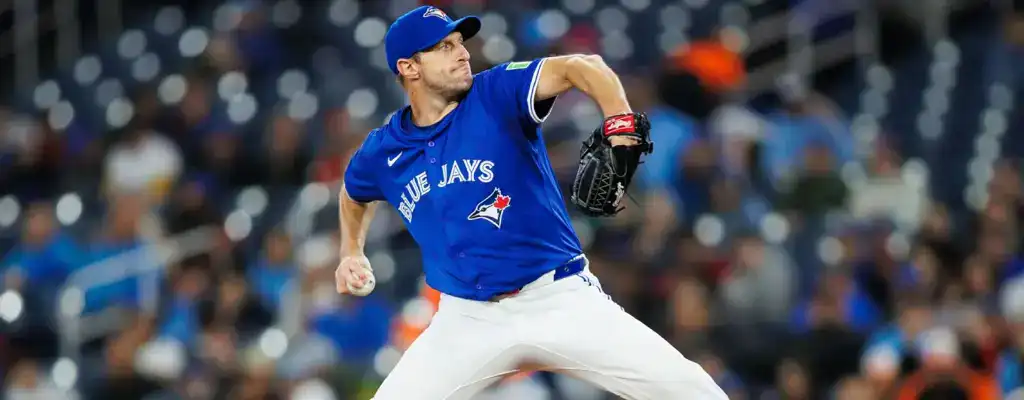 Toronto Blue Jays pitcher mid-delivery on the mound wearing blue jersey during a night game