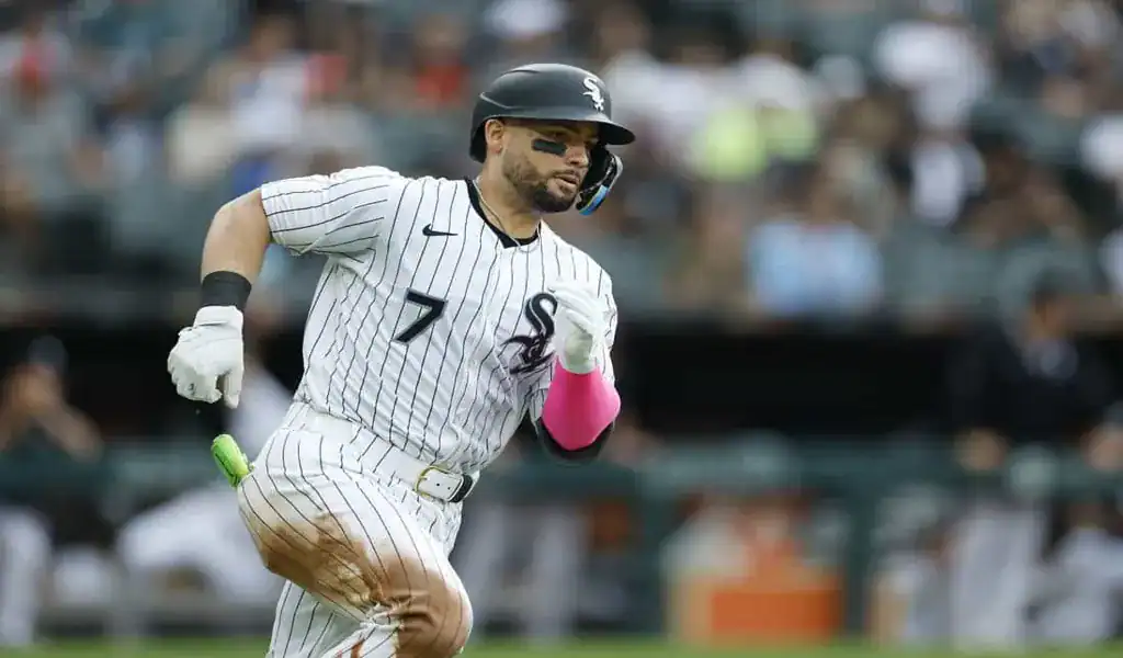 Chicago White Sox player sprinting to first base after making contact with the ball against the Cleveland Guardians