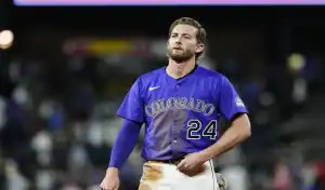 Colorado Rockies player walking off the field after a play during a game against the St. Louis Cardinals