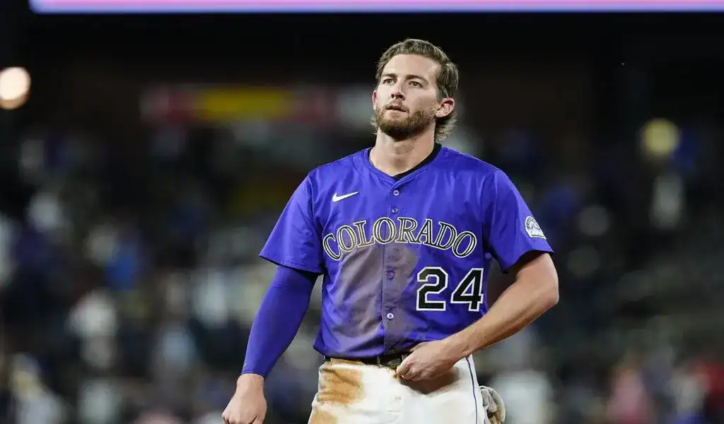 Colorado Rockies player walking off the field after a play during a game against the St. Louis Cardinals