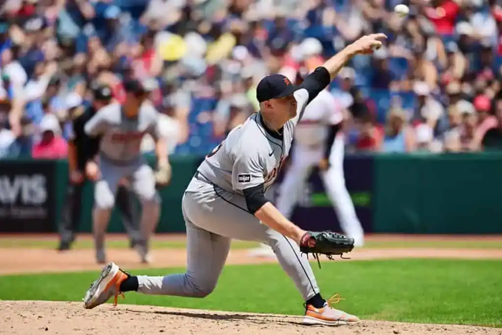 The image depicts a baseball player in a sports uniform throwing a ball on a baseball field. This outdoor scene captures the athletic spirit of the game