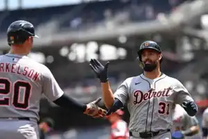 baseball player high-fiving another player, showcasing a moment of celebration or camaraderie on the field.