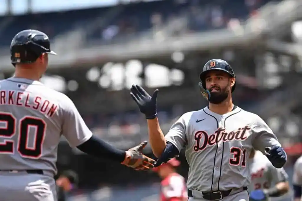 baseball player high-fiving another player, showcasing a moment of celebration or camaraderie on the field.