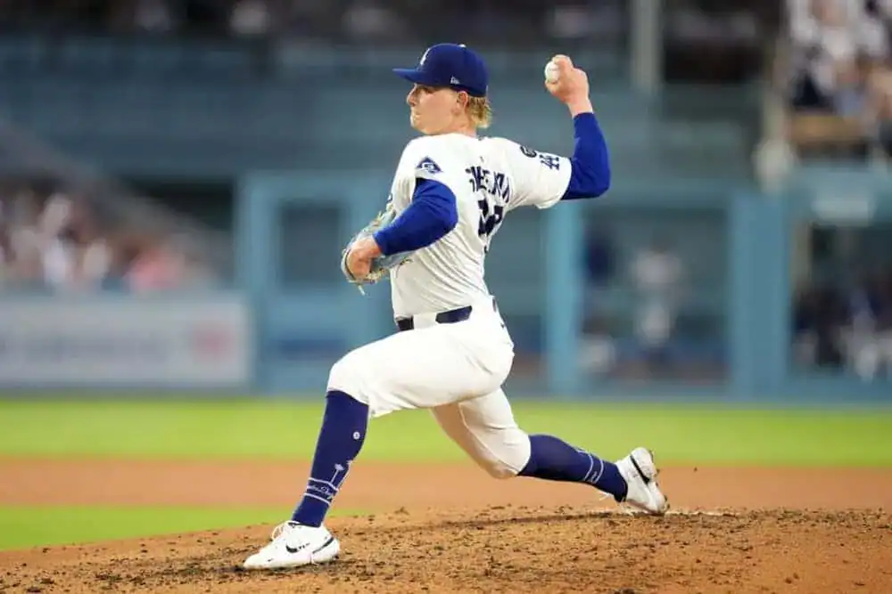 A baseball player is captured in the act of throwing a ball, showcasing the dynamic nature of the sport. He is dressed in a sports uniform and appears on a baseball field