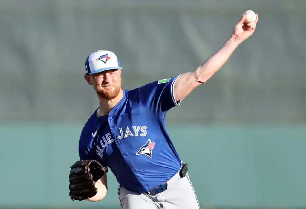 Toronto Blue Jays vs San Francisco Giants Picks and Predictions July 19th 2025 2 A Toronto Blue Jays pitcher in a blue jersey throws a baseball, showcasing his athletic form against a blurred background.