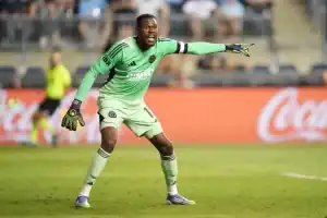 The image features a football player on a grassy field, likely during a match or practice session.
