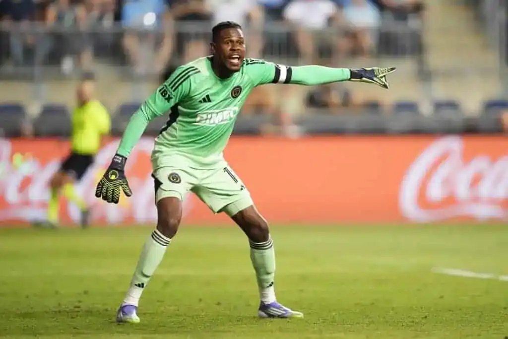 The image features a football player on a grassy field, likely during a match or practice session.